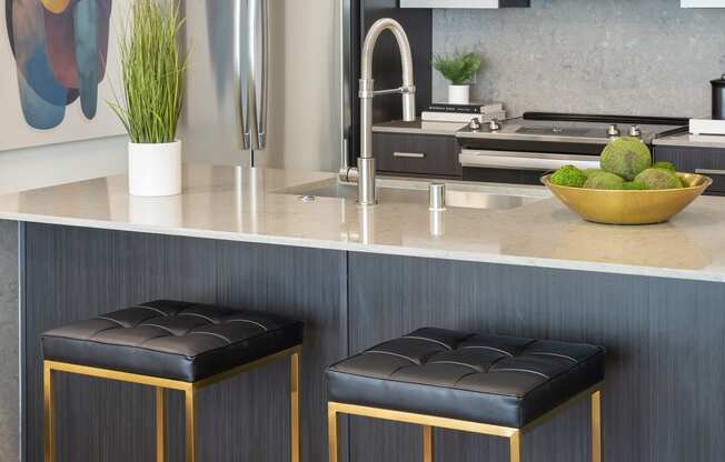 a kitchen with two stools in front of a counter