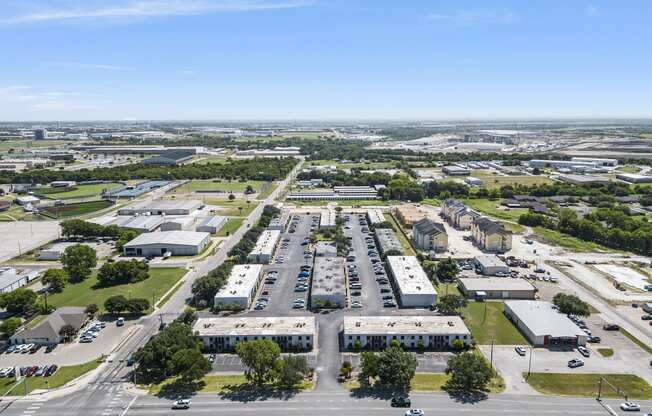 an aerial view of a parking lot with cars and buildings at Brookside Apartments, Hewitt, Texas