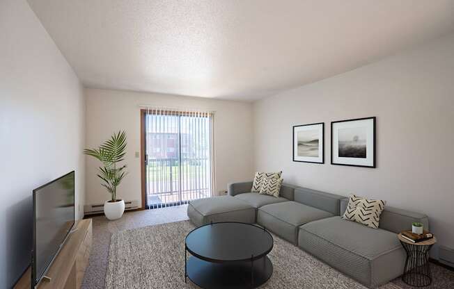 a living room with a gray couch and a tv. Fargo, ND Southview Village Apartments