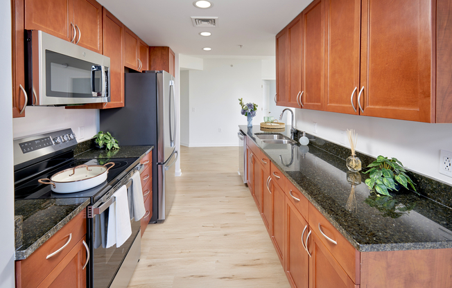 The expansive eat-in kitchen in the Copland floor plan showcases premium stainless steel appliances set against timeless granite surfaces. Updated fixtures and new wood-style vinyl plank flooring provide a fresh, high-end look to this generous 1,213-square-foot home.