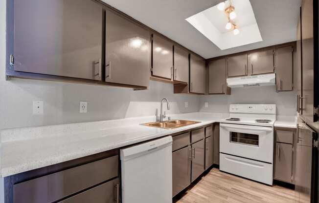 an empty kitchen with white appliances and stainless steel cabinets