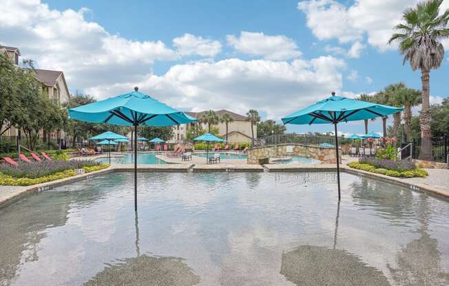 a large pool with umbrellas in the water at the resort  at The Verandah, Austin, Texas