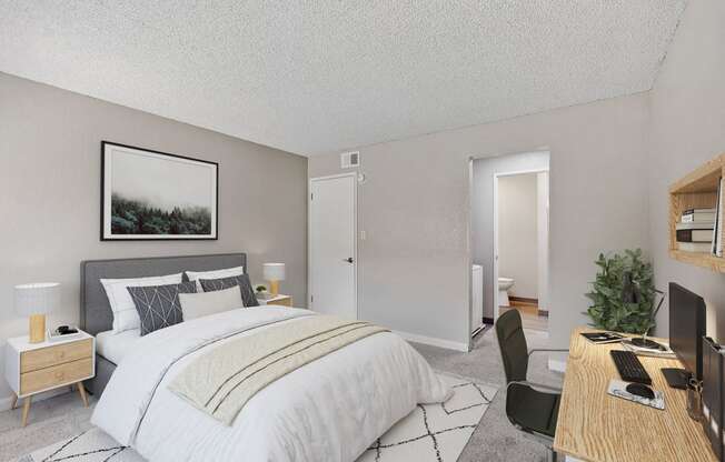 an open bedroom with a bed and a desk with a computer