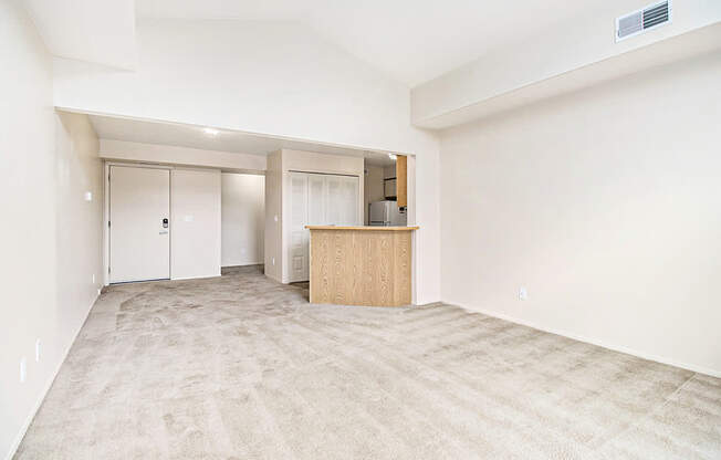 A living room with a carpeted floor and a high ceiling at Arbor Lakes Apartments in Elkhart, IN