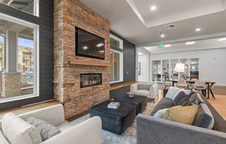 The Modera Lacey resident clubhouse with a modern fireplace and lounge seating is where modern elegance meets cozy warmth.
