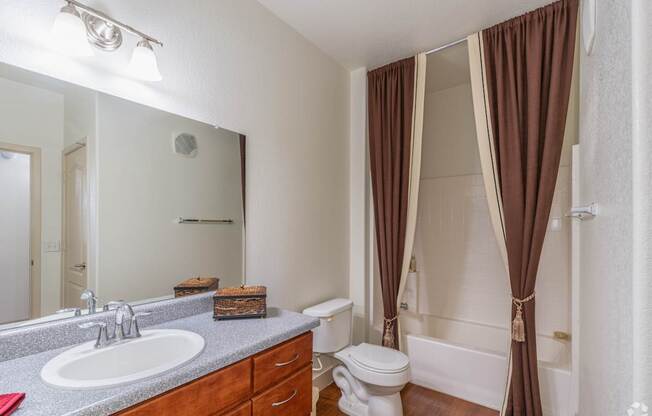 A bathroom with brown curtains and a white toilet.