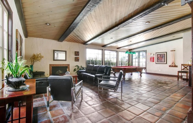 a large living room with a pool table in the corner