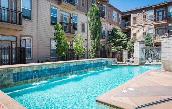 a swimming pool with an apartment building in the background