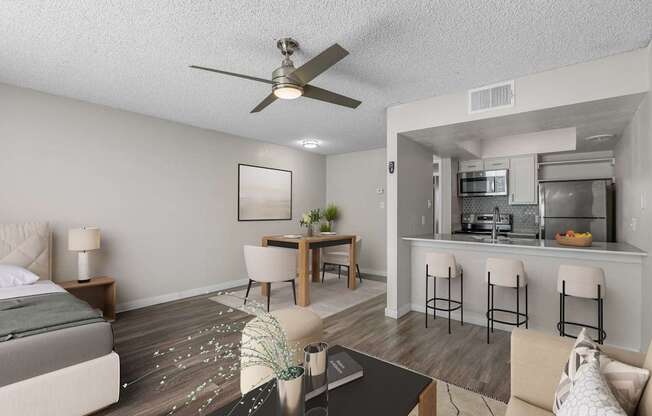 A modern living room with a kitchen area in the background.