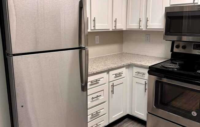 a kitchen with white cabinets and stainless steel appliances