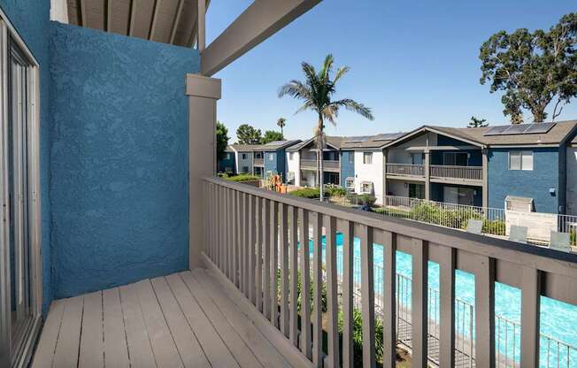 A balcony with a view of a pool.