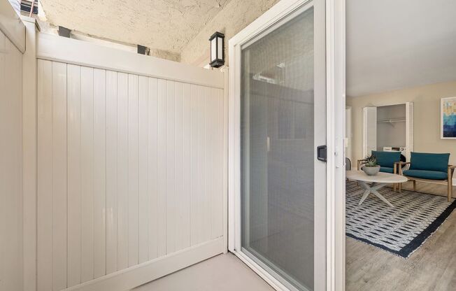 an open door leading to a living room with a couch and coffee table in the background