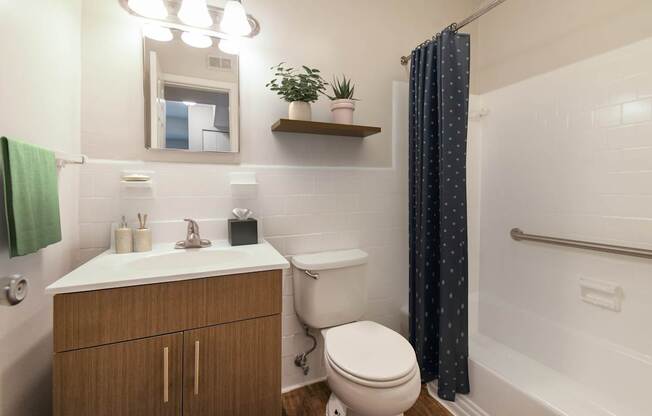 A bathroom with a toilet, sink, and shower.