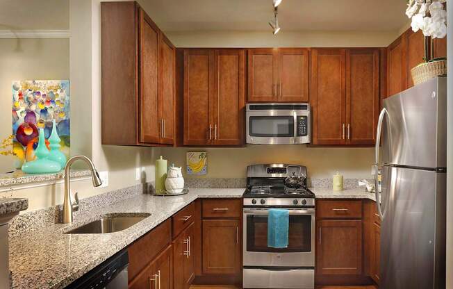 A kitchen with brown cabinets and a stainless steel refrigerator.