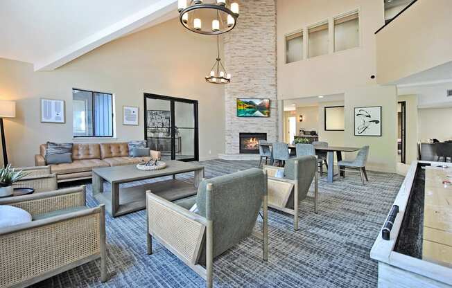 a clubhouse with couches chairs and tables and a fireplace