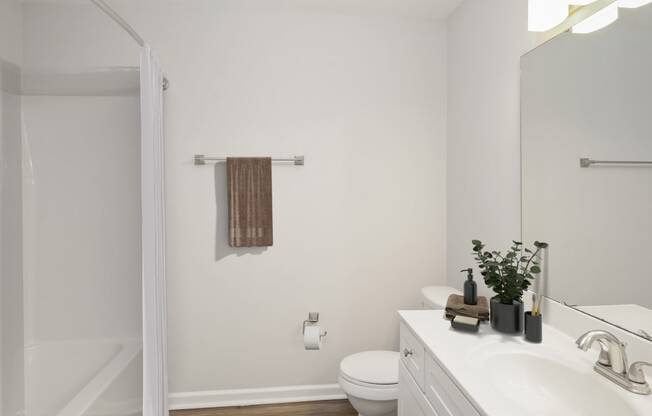 a bathroom with white walls and a white toilet next to a white sink