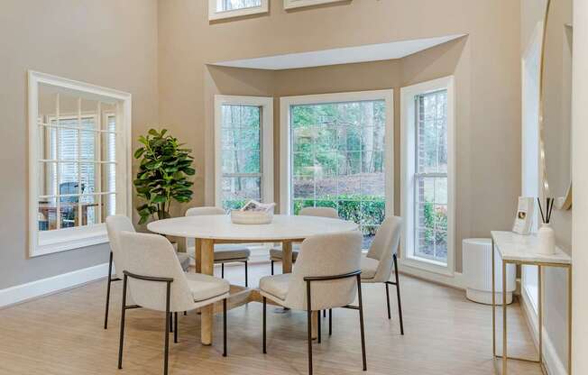 A dining room with a table and chairs.