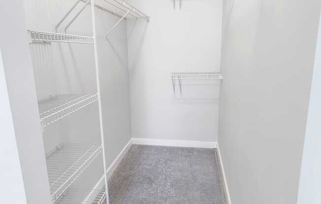 A walk-in closet with white shelving at West Inman Lofts, Atlanta