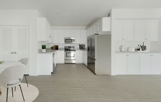 a white kitchen with stainless steel appliances and white cabinets