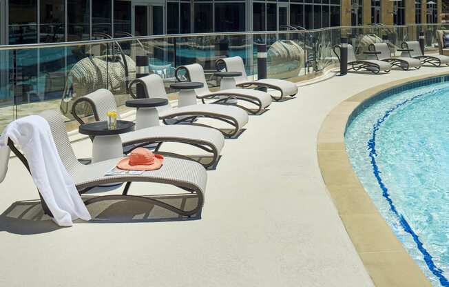 a row of lounge chairs next to a pool