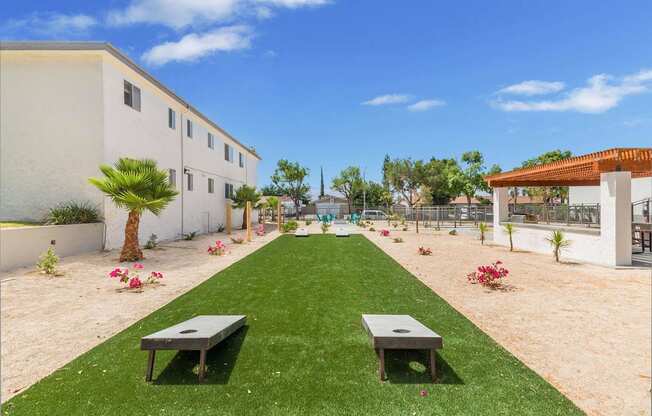 a garden outside a building with grass and benches at Sunnymead Apts Apartments, Moreno Valley, CA