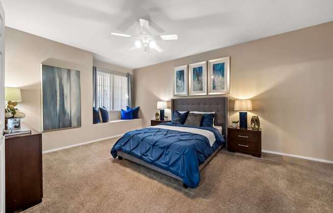 A bedroom with a bed, nightstands, and pictures on the wall.