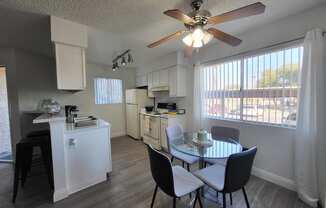 a kitchen and dining area with a large window and a ceiling fan