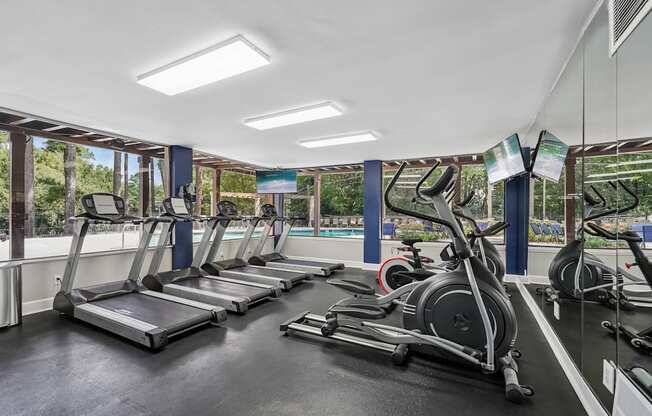 A gym with treadmills and elliptical machines.