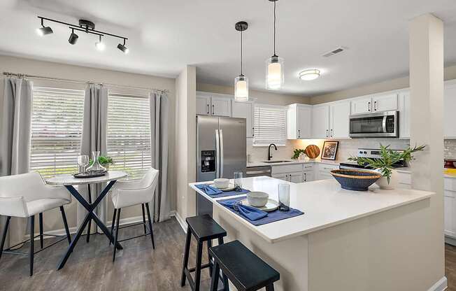 A kitchen with a table and chairs by a window.