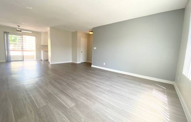 the living room and dining room of an apartment with wood flooring