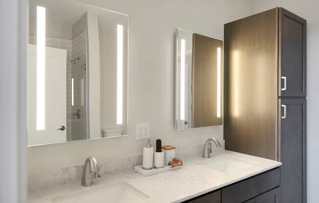 a bathroom with two sinks and two mirrors