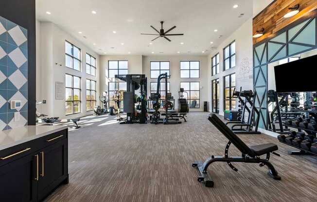 A gym with a variety of equipment including a bench press.