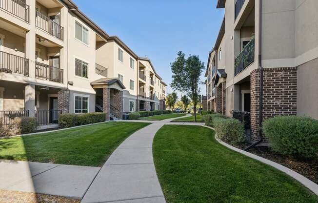 a walkway between two apartment buildings on a sunny day