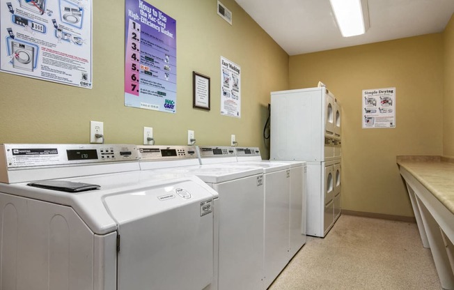 a laundry room with four washing machines and a refrigerator