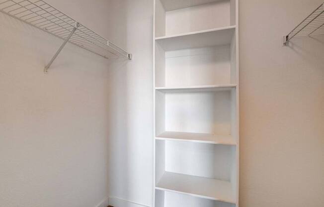 A white shelving unit in a room with white walls.