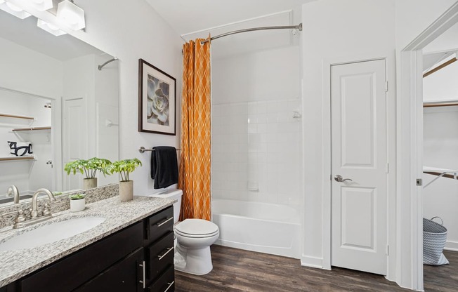 A bathroom with a white toilet, sink, and bathtub.