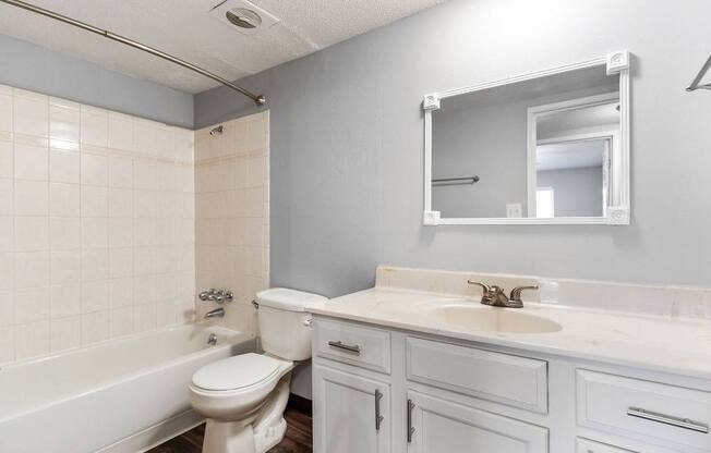 A white bathroom with a toilet, sink, and bathtub.