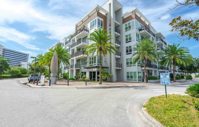 A modern apartment building with a blue sign in front.