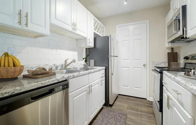 a kitchen with white cabinets and a black refrigerator
