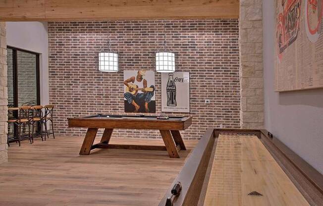 a pool table in a room with a brick wall at Hunters Creek Apartments, Texas, 76210