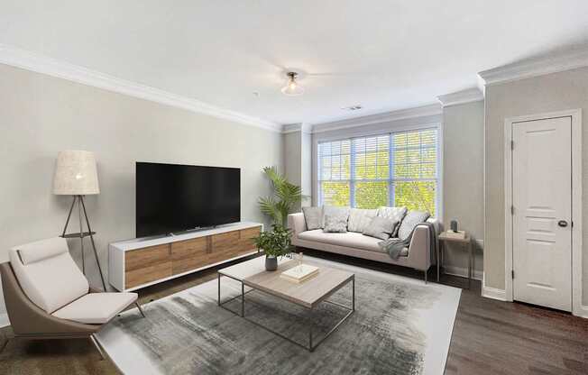 A modern living room with a white chair, a black television, and a glass coffee table.