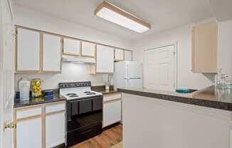 a kitchen with white cabinets and black appliances