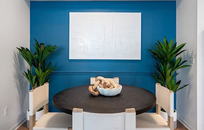 a dining room with a blue wall and a table and chairs