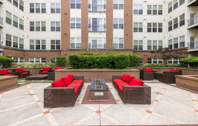 A courtyard with red couches and a fountain in the middle.