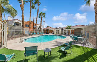 Community Swimming Pool with Pool Furniture at Stonegate Apartments located in Las Vegas, NV.