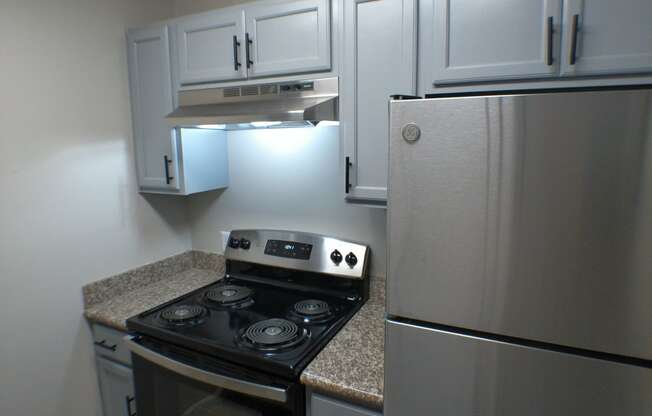 a kitchen with white cabinets and a stove and refrigerator