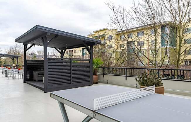 A ping pong table is in the middle of a patio.