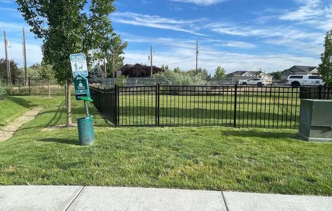 a park with a fence and a sign in the grass