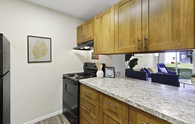 Kitchen with Plank Flooring, Efficient Appliances, and Light Brown Cabinetry at Pacific Park Apartment Homes, WA 98026