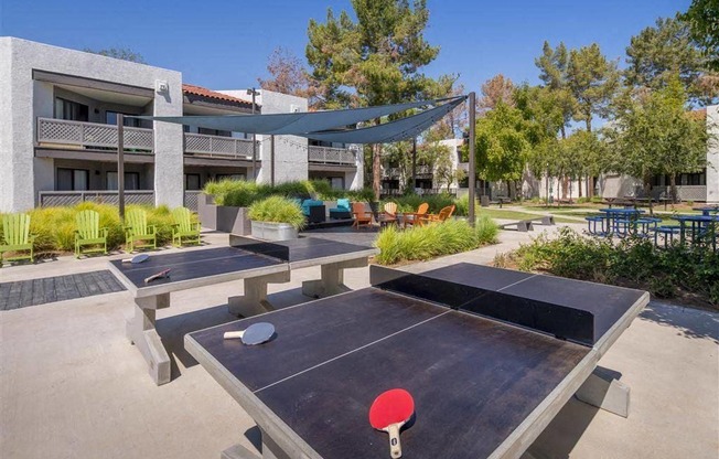 A ping pong table is in the middle of a concrete patio.